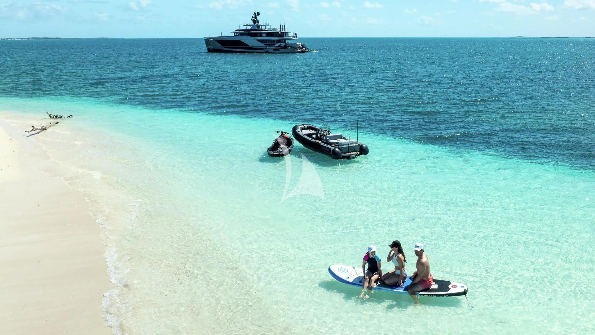 a group of people on a beach with a boat in the water aboard ENTERPRISE Yacht for Charter