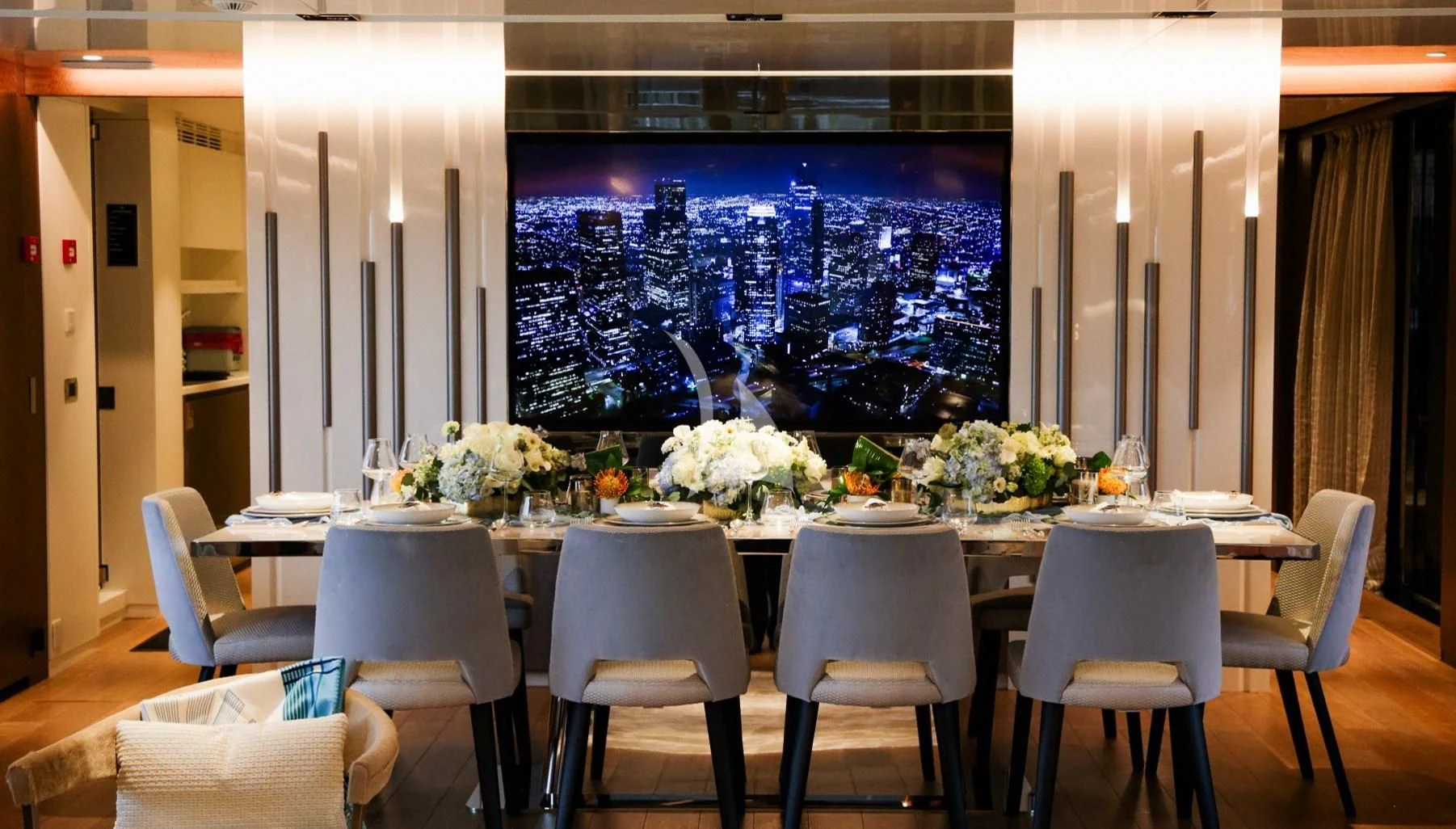 a large room with a table and chairs and flowers on the table aboard ENTERPRISE Yacht for Charter