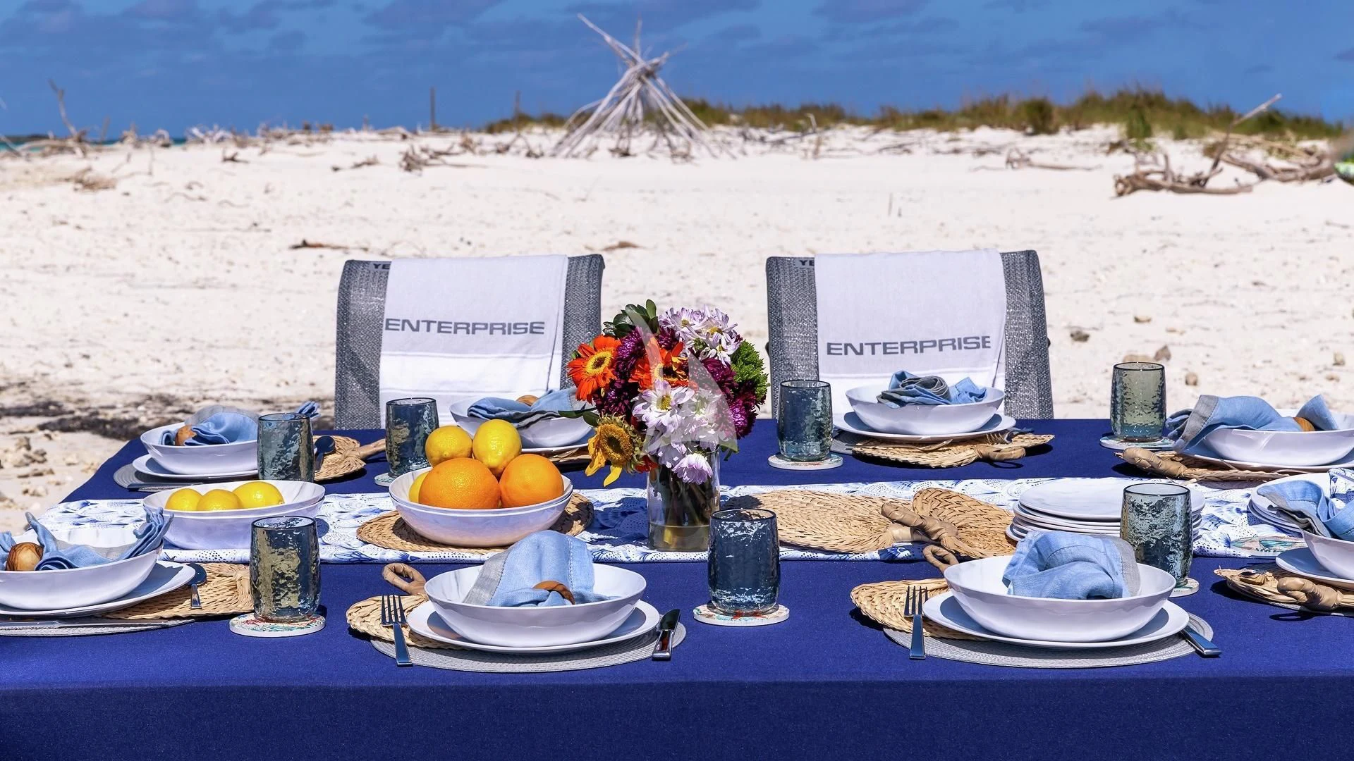 a table set with plates and flowers aboard ENTERPRISE Yacht for Charter