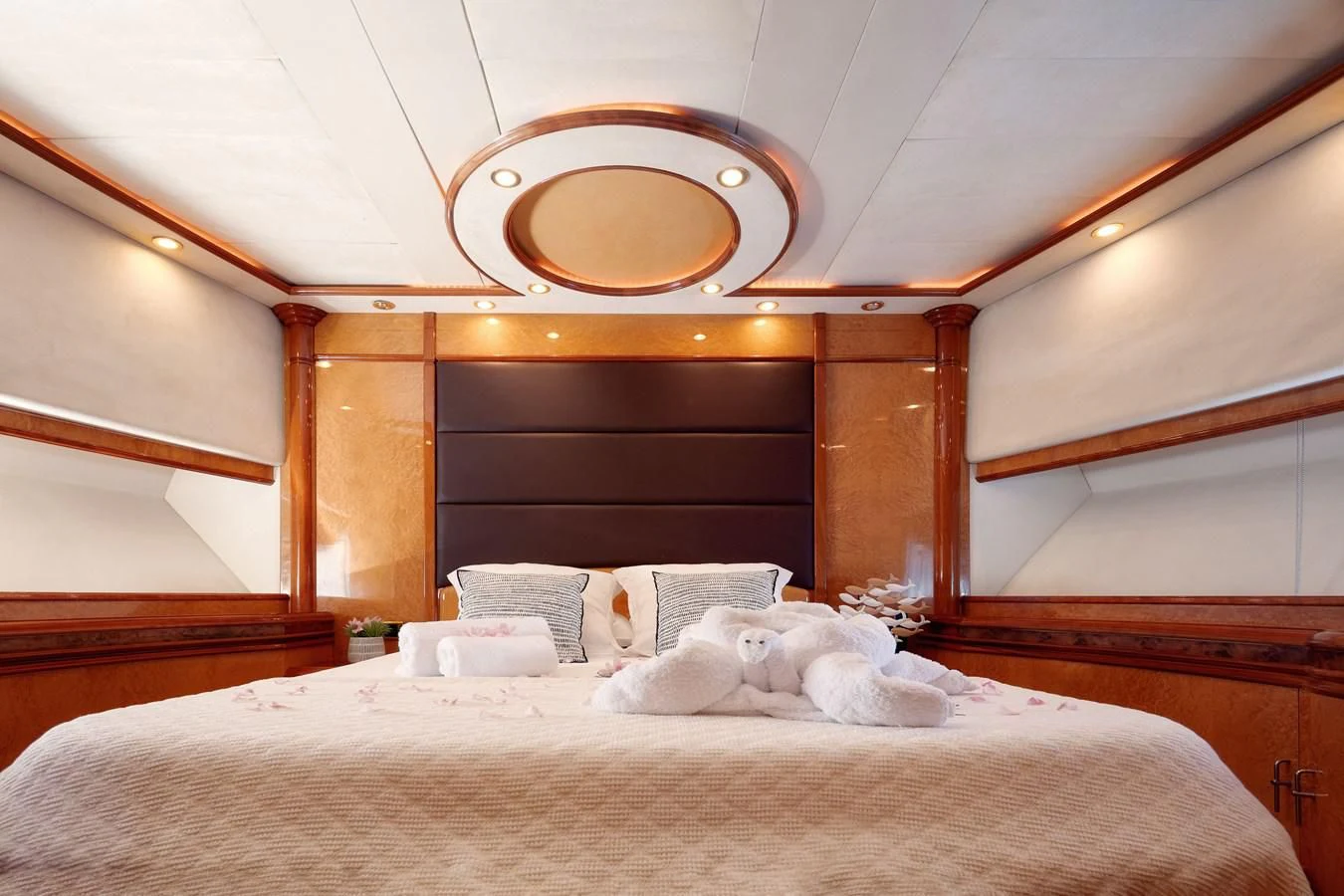 a bed with a white sheet and a round mirror above it aboard NEPHENTA PRIMERO Yacht for Sale