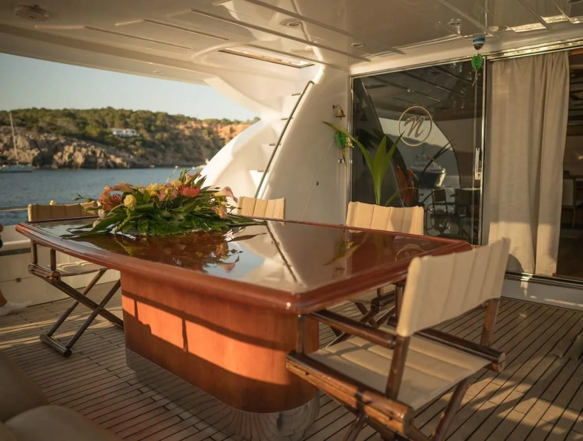 a table with chairs and plants on it aboard NEPHENTA PRIMERO Yacht for Sale