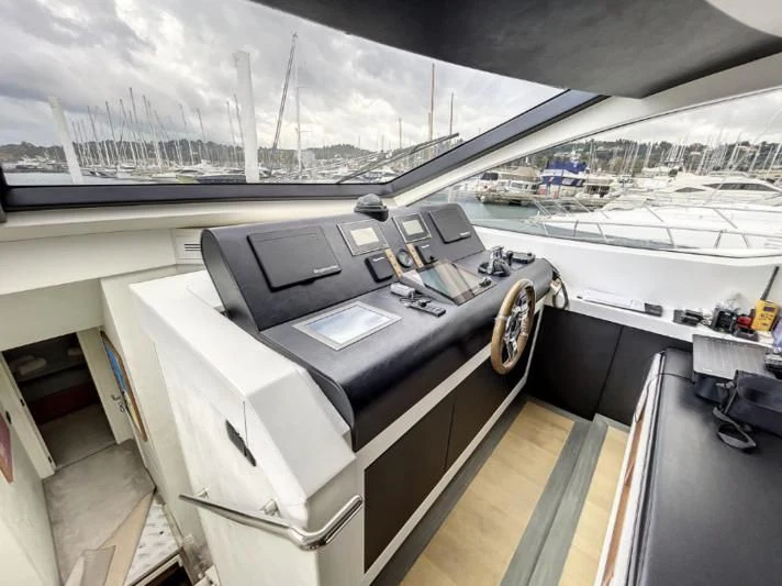 a room with a large table and a large window with a view of the water and a city aboard LA FENICE Yacht for Charter