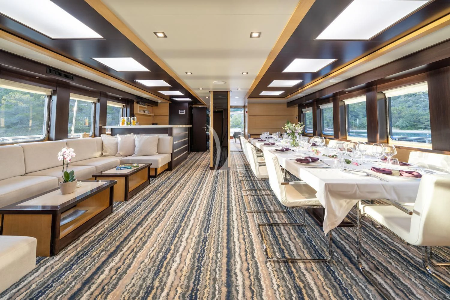 a room with tables and chairs aboard NAVILUX Yacht for Sale