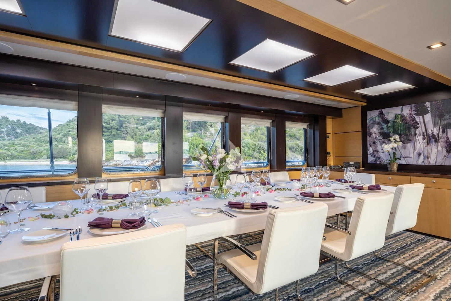 a room with tables and chairs aboard NAVILUX Yacht for Sale