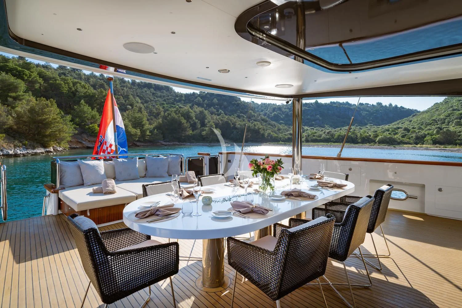 a table set for a meal on a deck overlooking a lake aboard NAVILUX Yacht for Sale