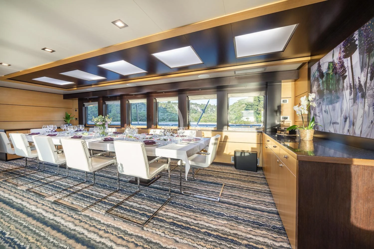 a room with tables and chairs aboard NAVILUX Yacht for Sale