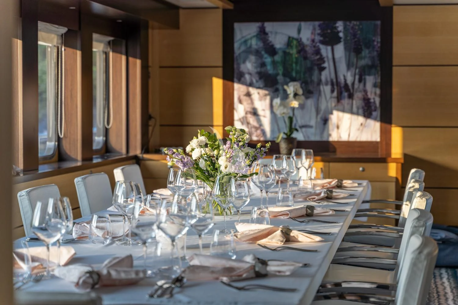 a table set with glasses and flowers aboard NAVILUX Yacht for Sale
