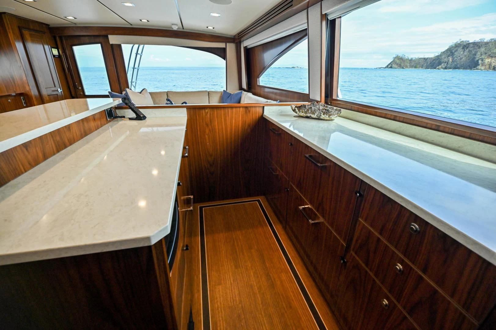 a wooden kitchen with a large window overlooking the ocean aboard EL LOBO Yacht for Sale