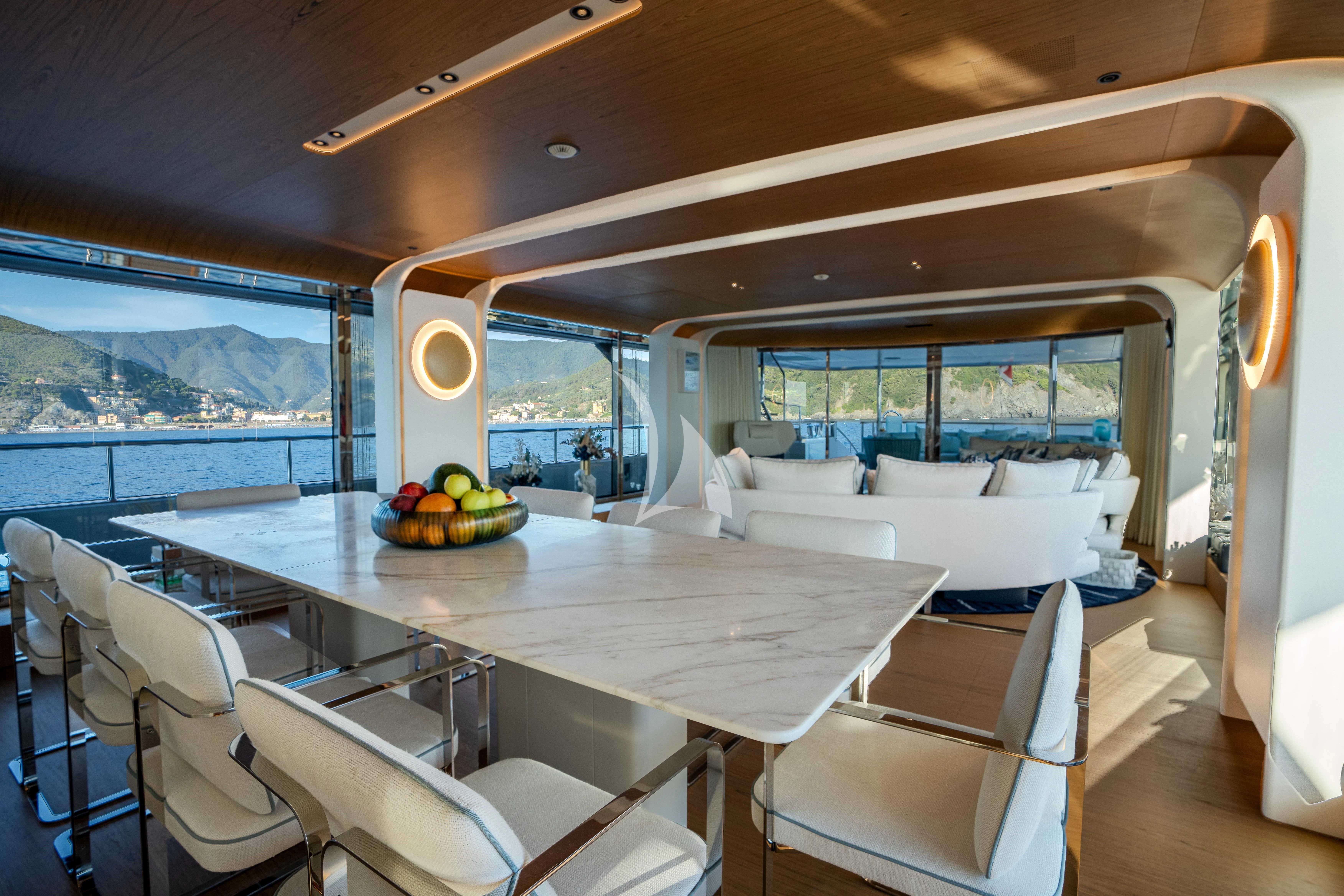 a room with a table chairs and a couch aboard EH2 Yacht for Sale
