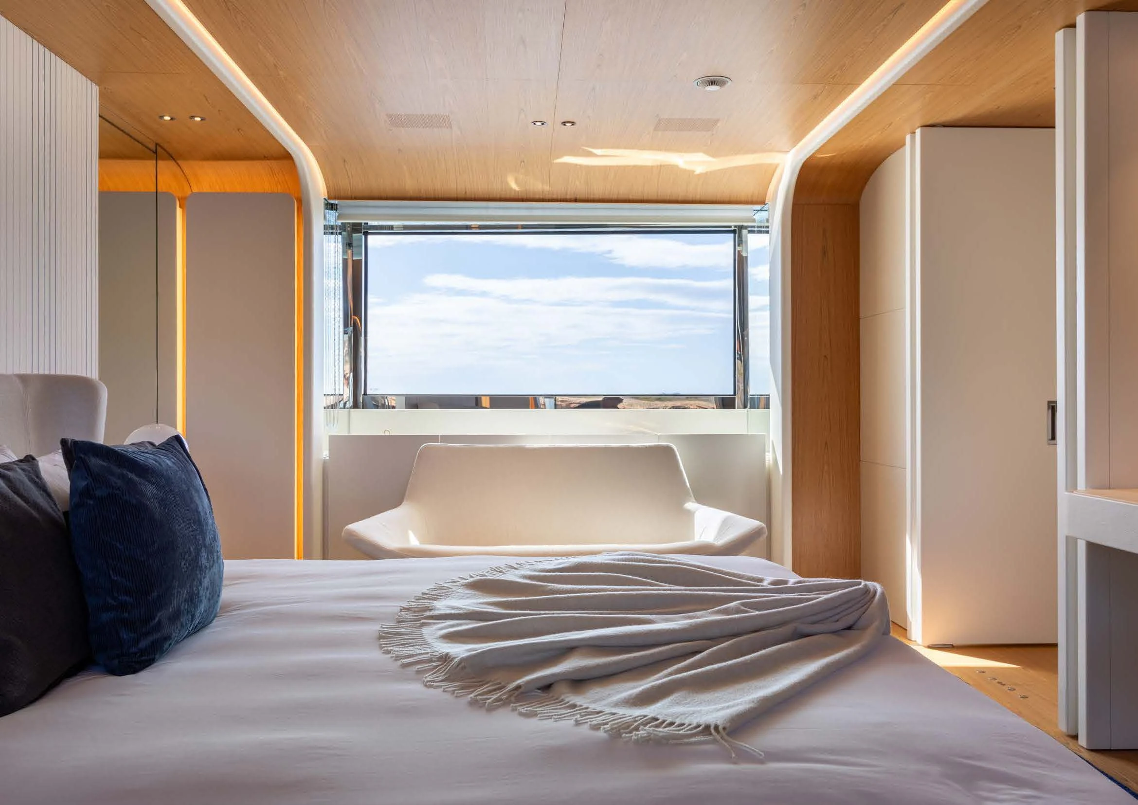 a bed with a large window aboard EH2 Yacht for Sale