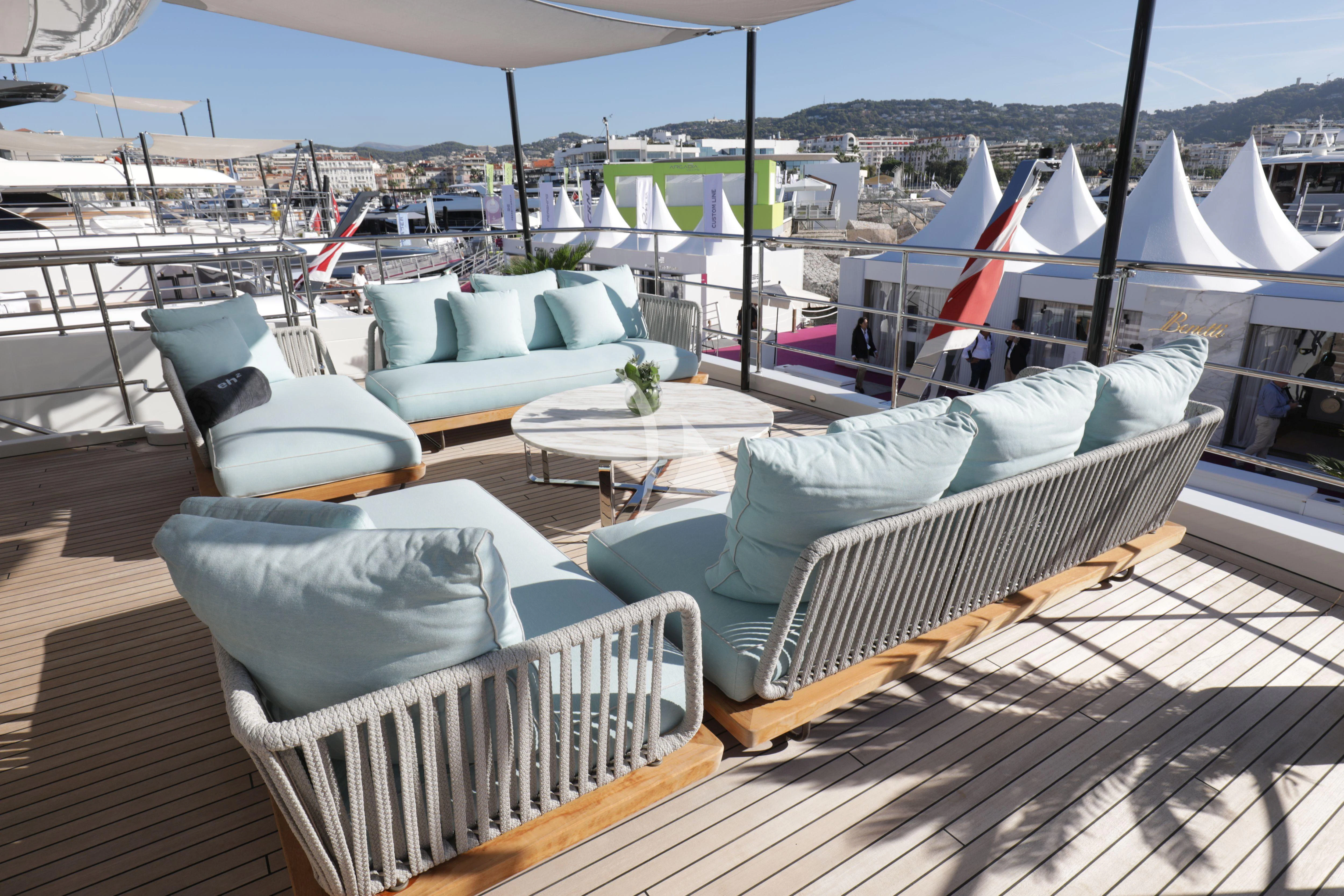 a deck with chairs and tables aboard EH2 Yacht for Sale