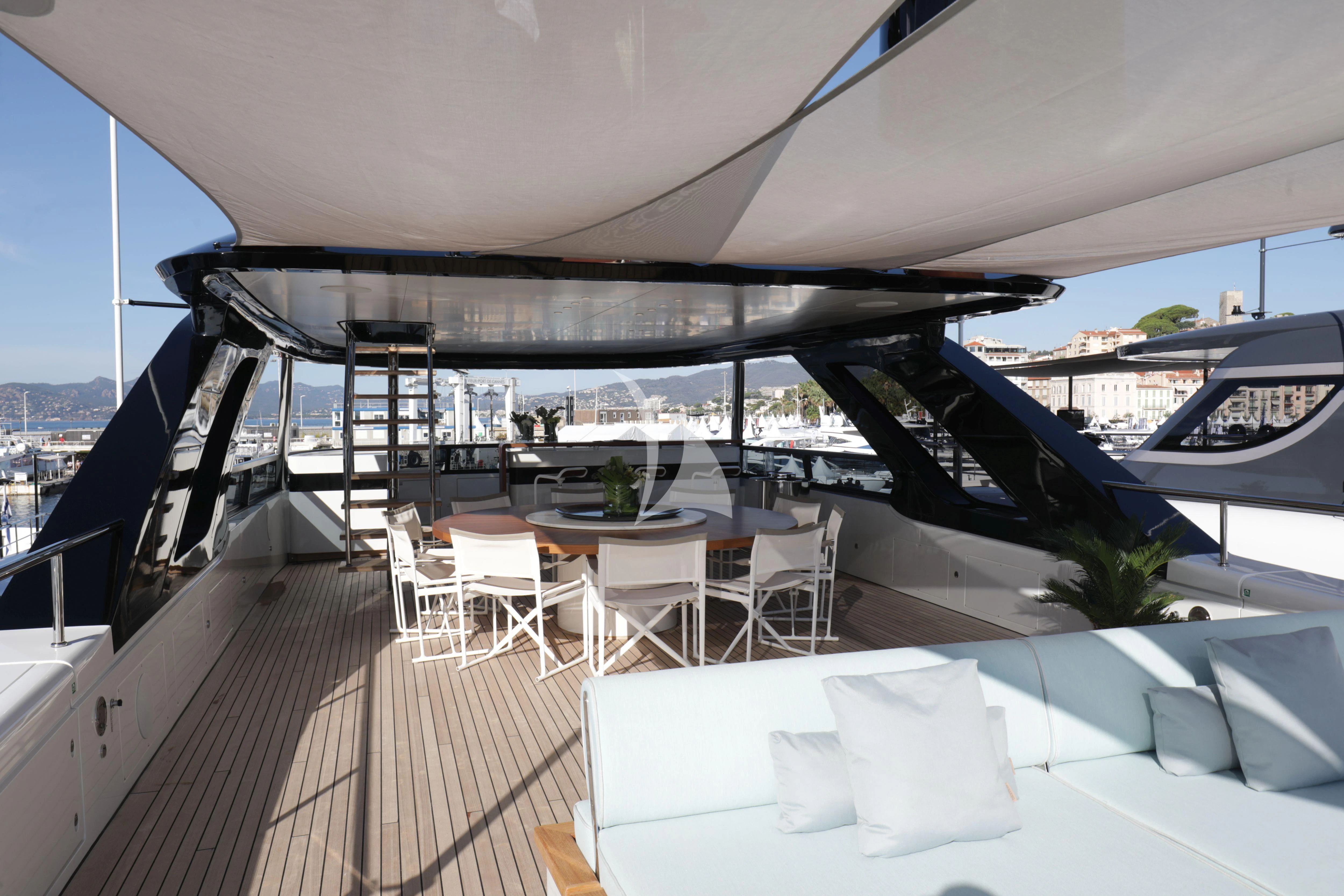 a deck with a table and chairs on it aboard EH2 Yacht for Sale