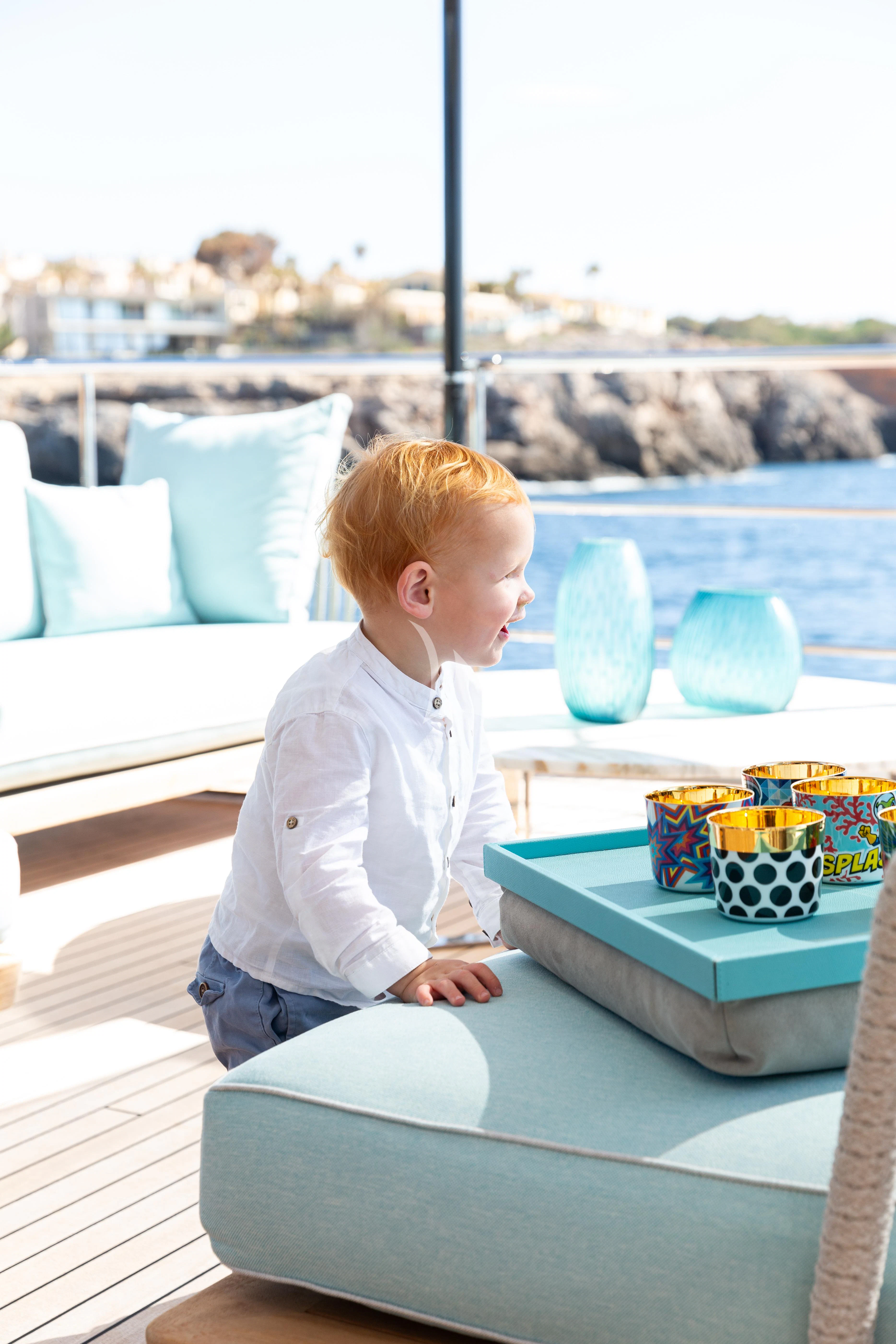 a baby sitting on a table aboard EH2 Yacht for Sale