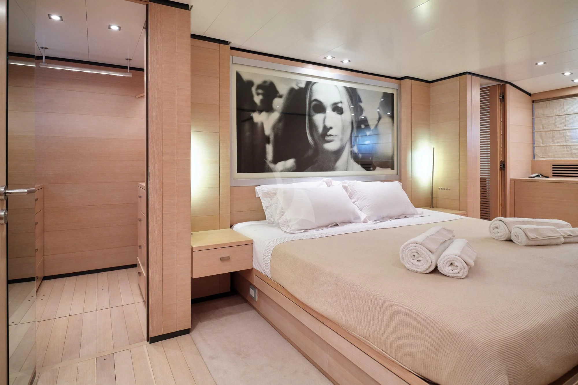 a hotel room with a bed and a painting on the wall aboard AMICI PER SEMPRE Yacht for Charter
