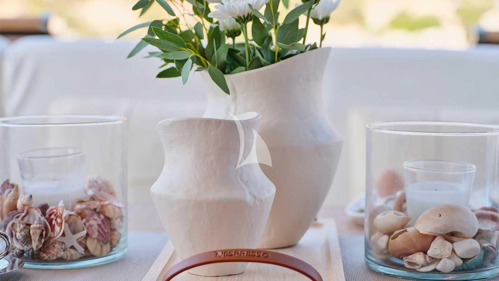 a white vase with flowers and rocks aboard AMICI PER SEMPRE Yacht for Charter