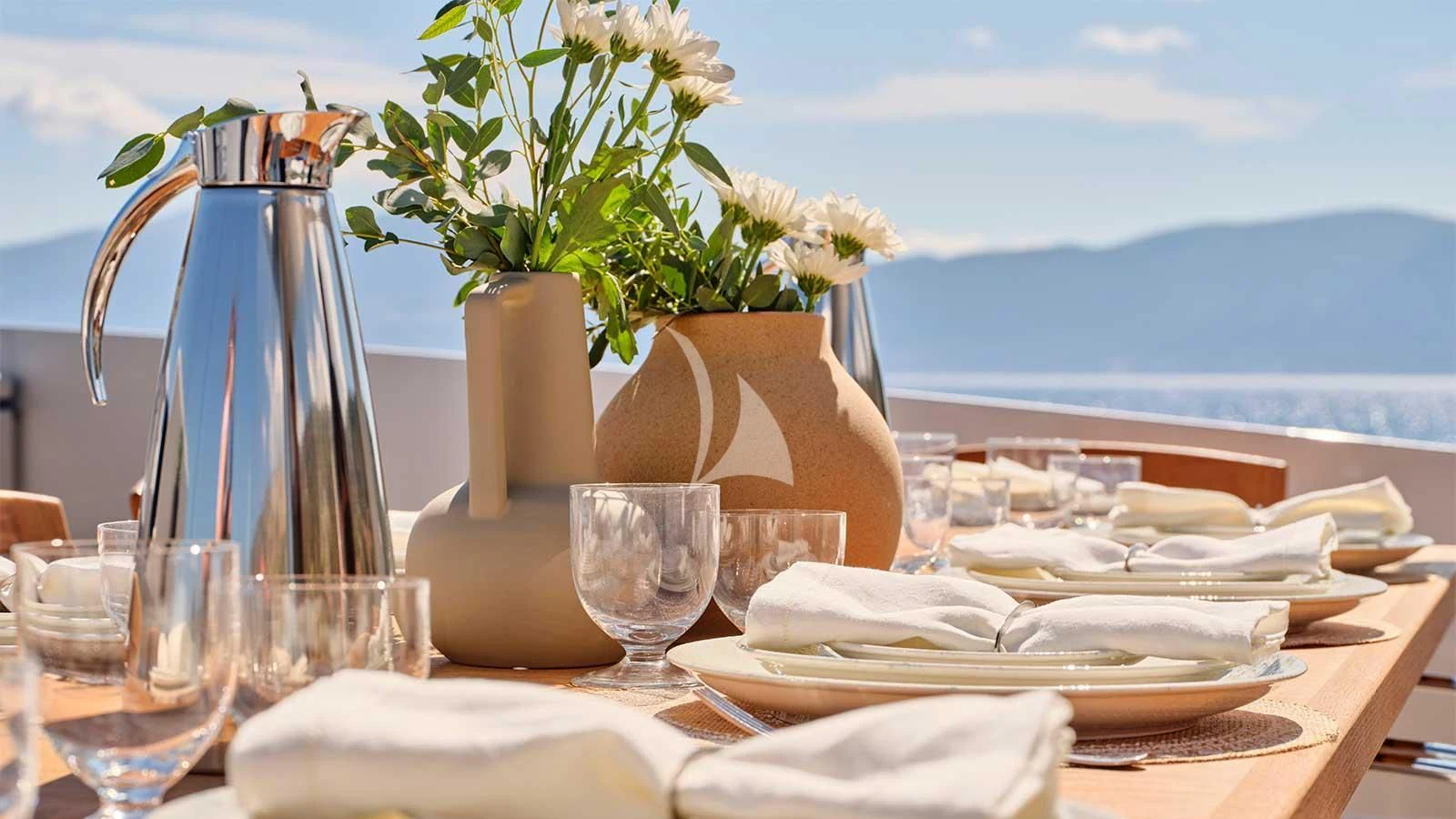 a table with plates and glasses aboard AMICI PER SEMPRE Yacht for Charter