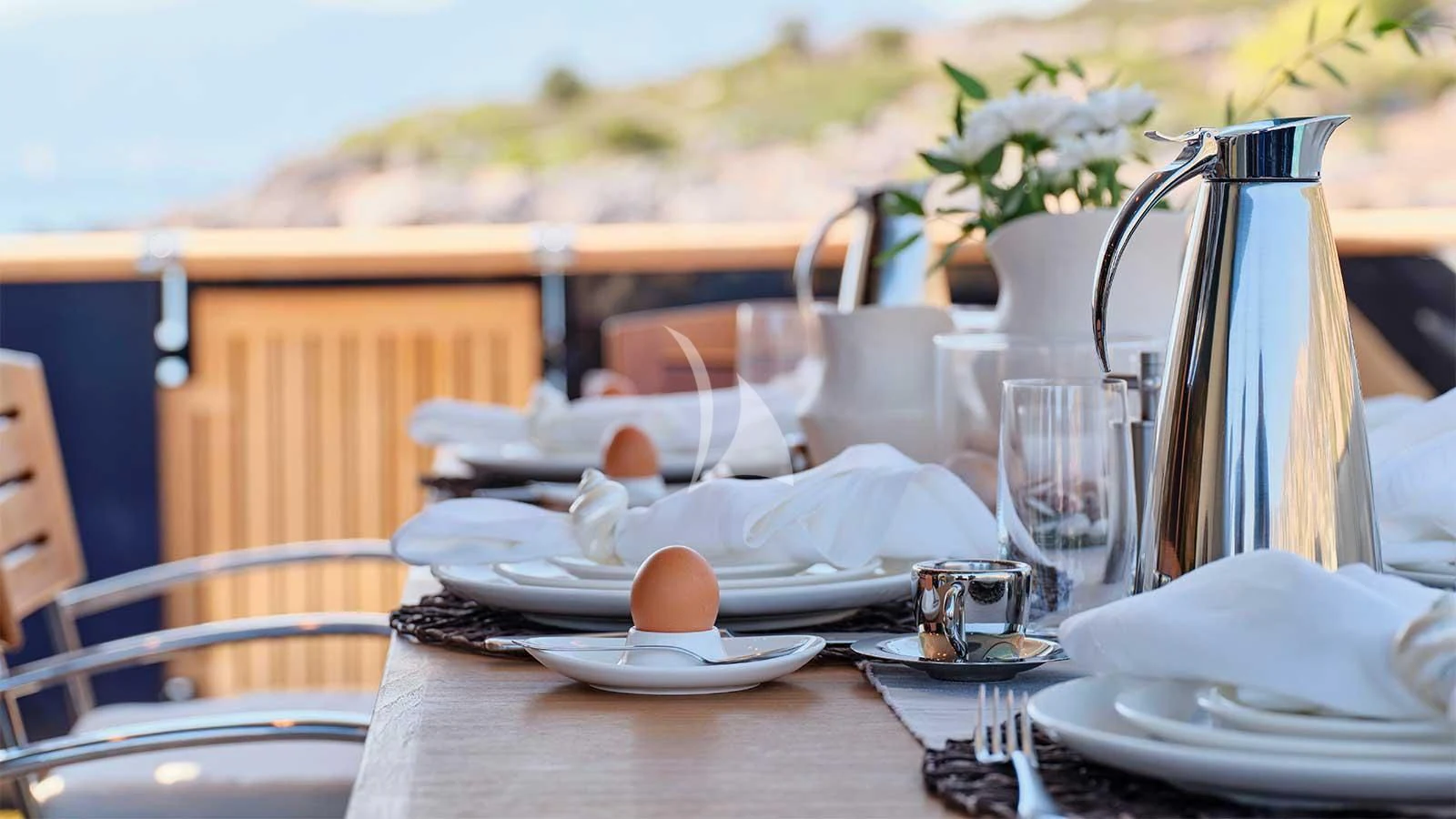 a table with plates and silverware aboard AMICI PER SEMPRE Yacht for Charter