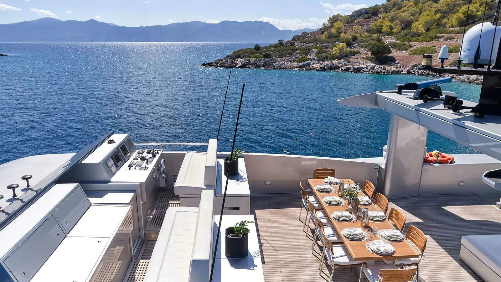 a deck with a view of the ocean and mountains aboard AMICI PER SEMPRE Yacht for Charter
