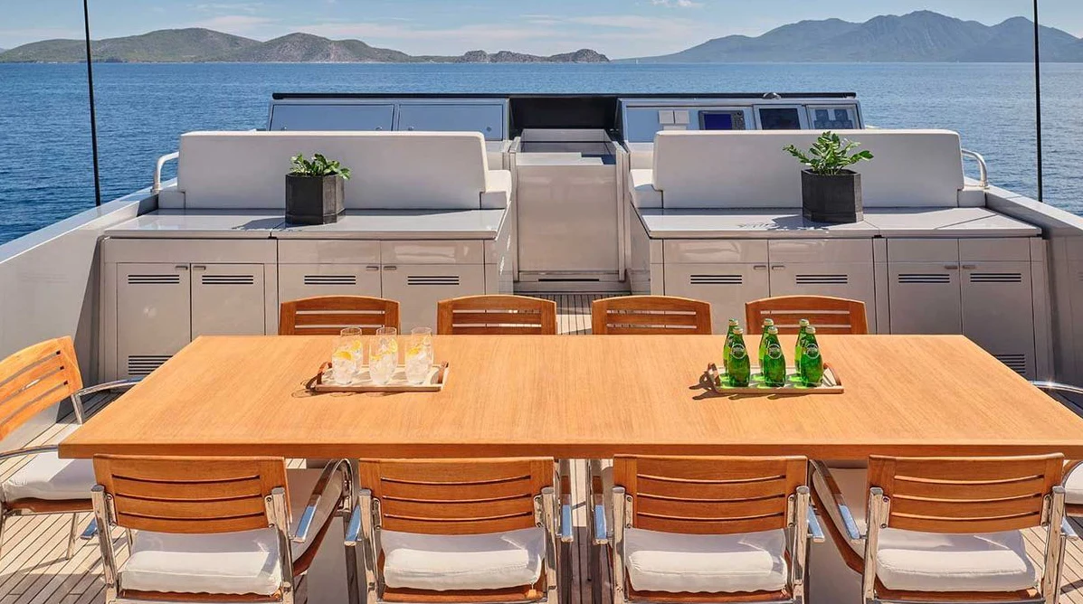 a table with a bottle and a couple of glasses on it aboard AMICI PER SEMPRE Yacht for Charter