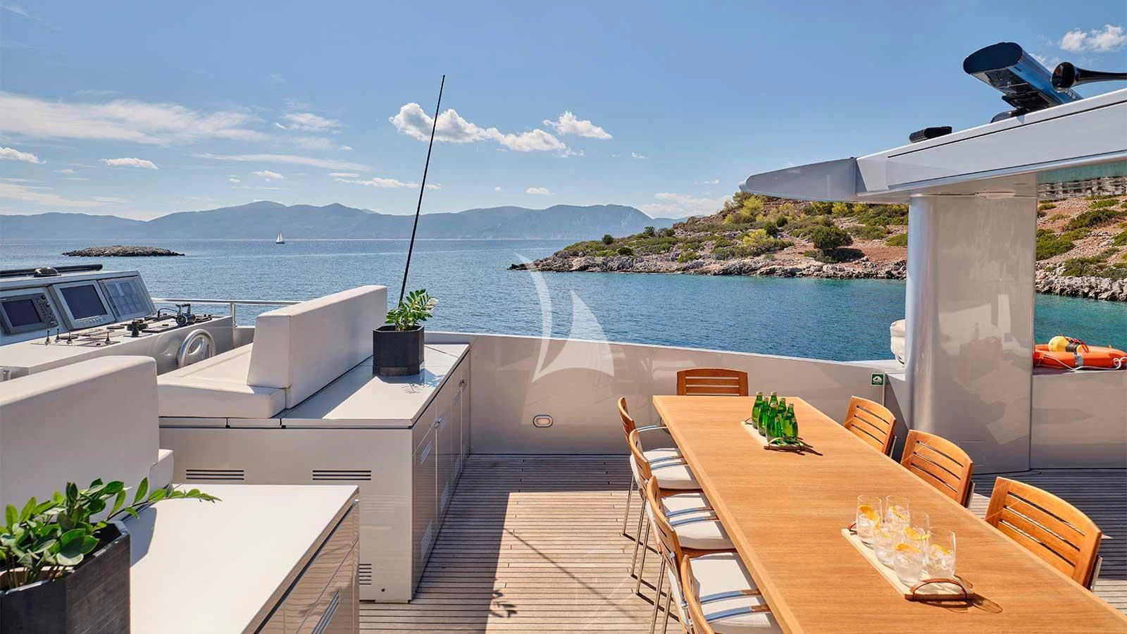 a table and chairs on a deck overlooking a body of water aboard AMICI PER SEMPRE Yacht for Charter