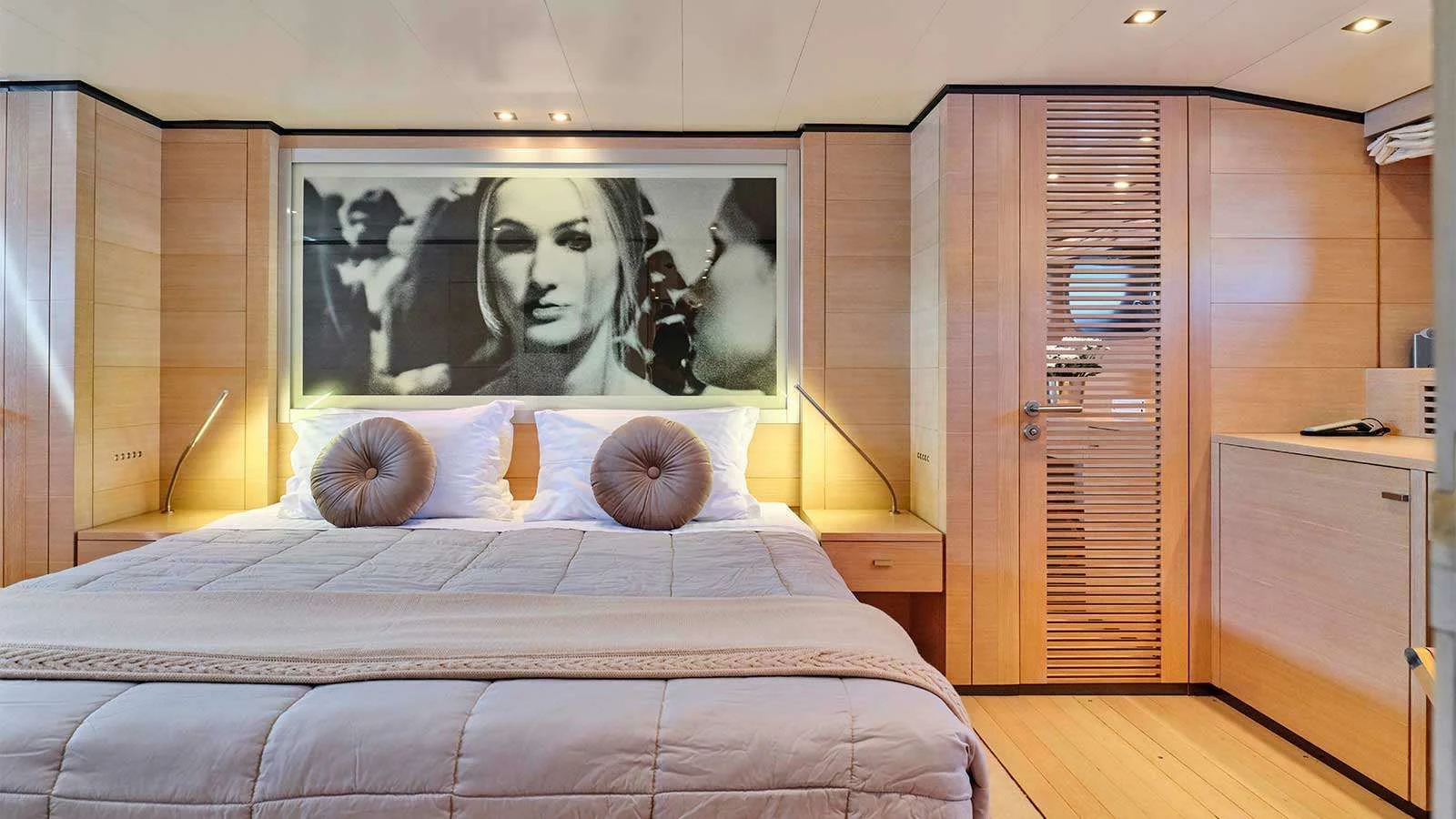 a bed with a painting on the wall aboard AMICI PER SEMPRE Yacht for Charter