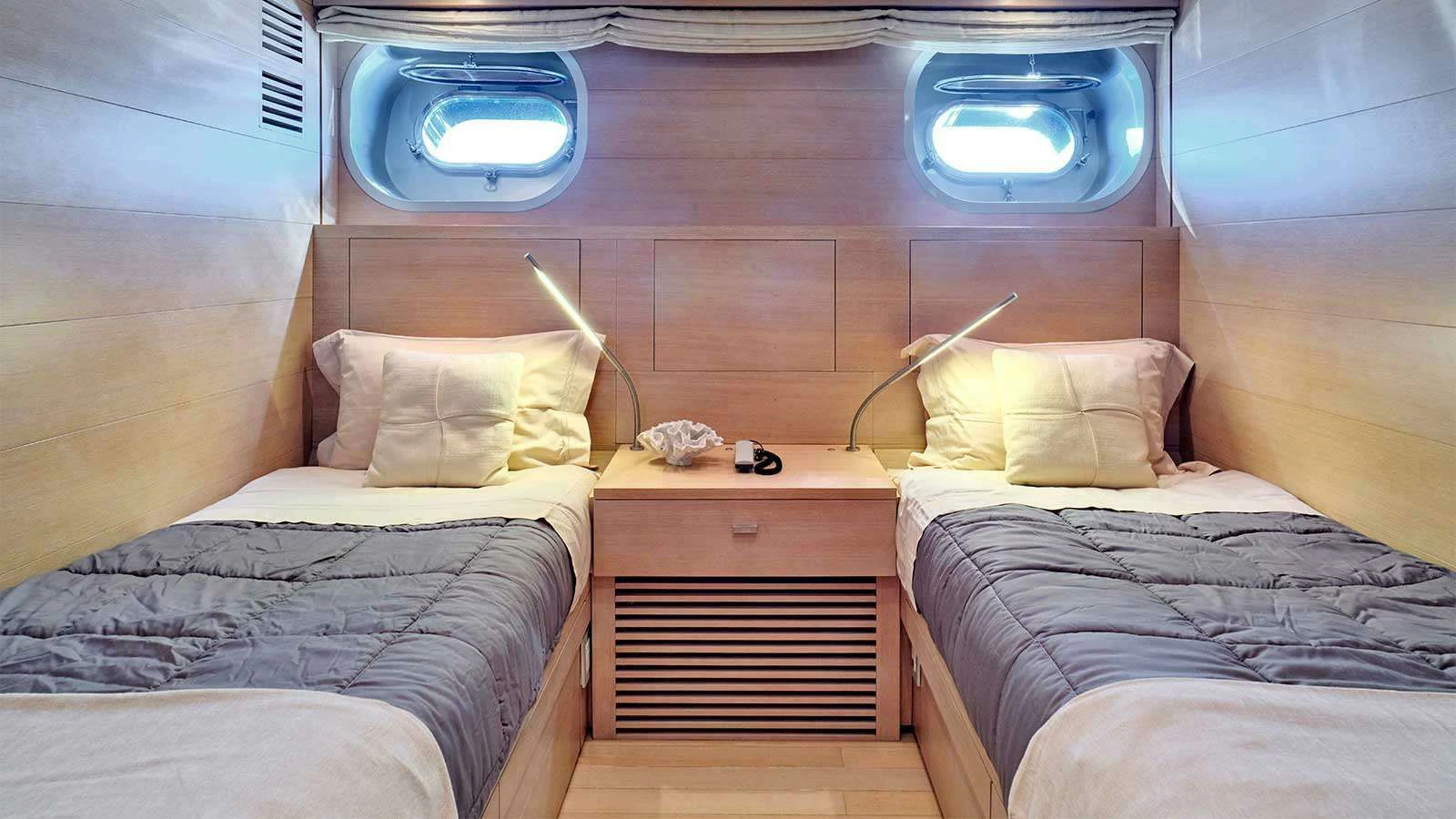 a room with beds and a window aboard AMICI PER SEMPRE Yacht for Charter