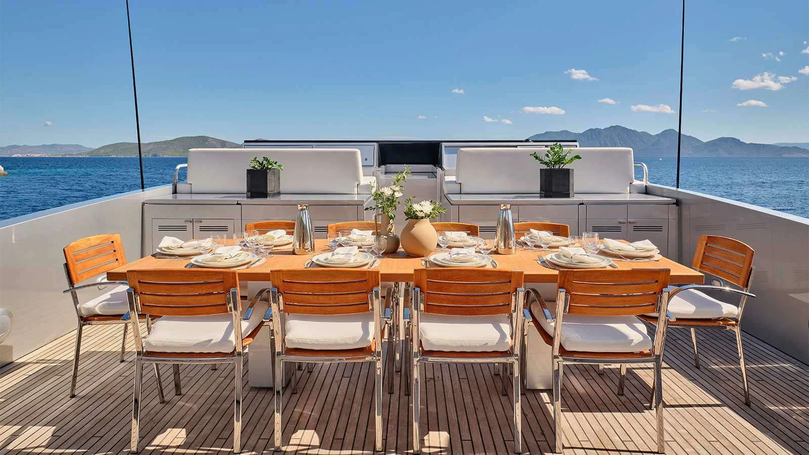 a table set for a meal on a deck overlooking the ocean aboard AMICI PER SEMPRE Yacht for Charter