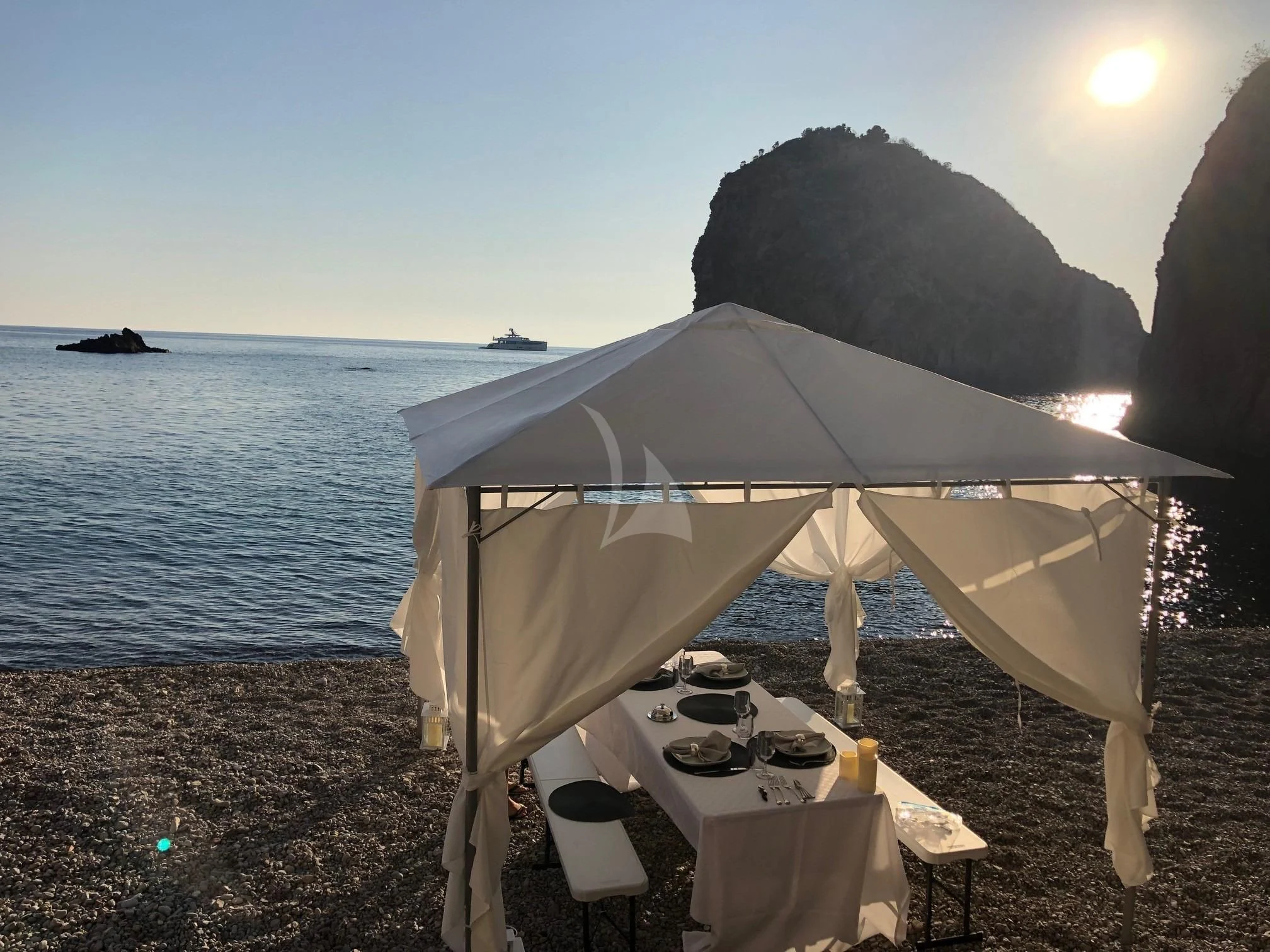 a table and umbrella on a beach aboard CALYPSO I Yacht for Charter