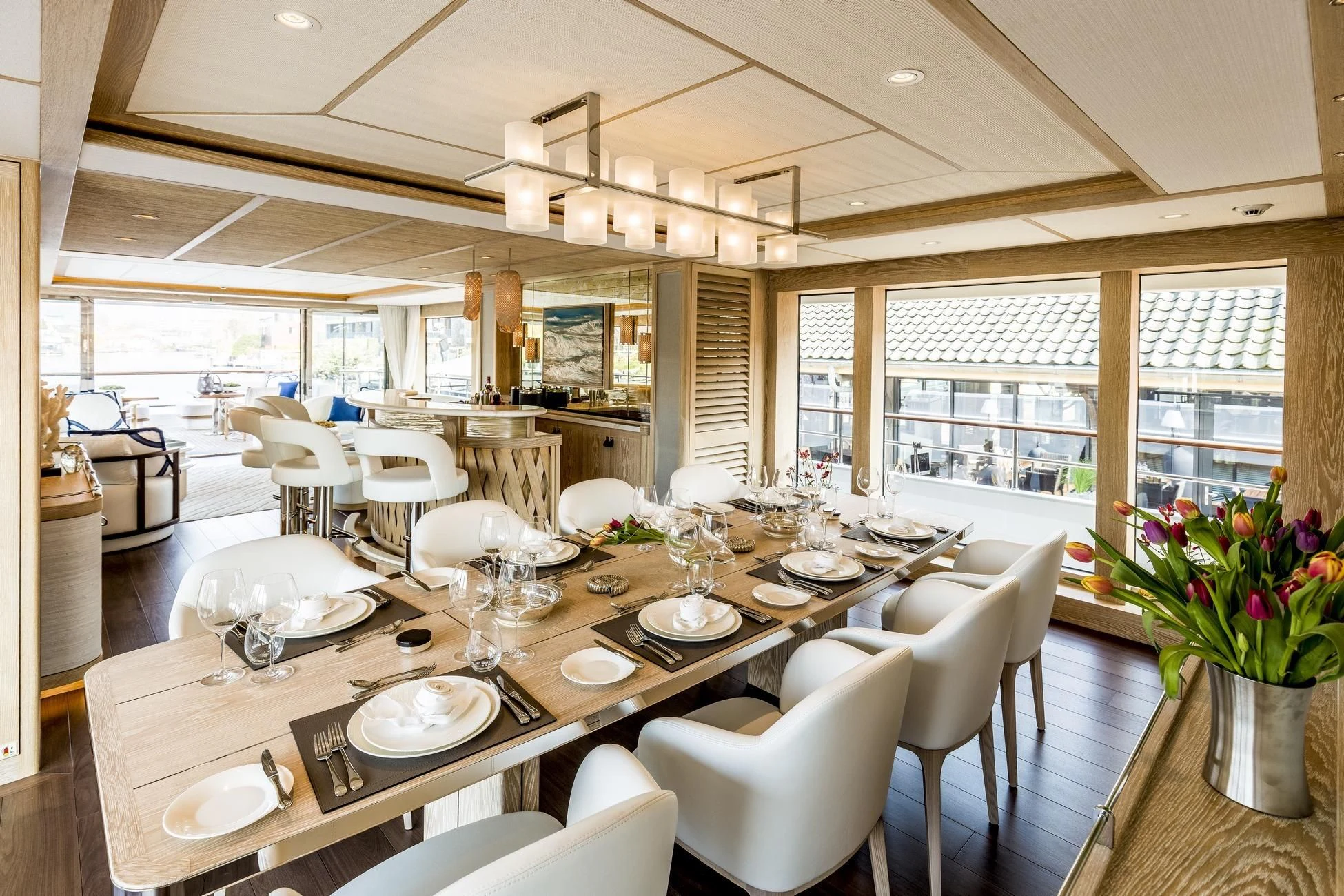 a large dining room with white chairs aboard CALYPSO I Yacht for Charter