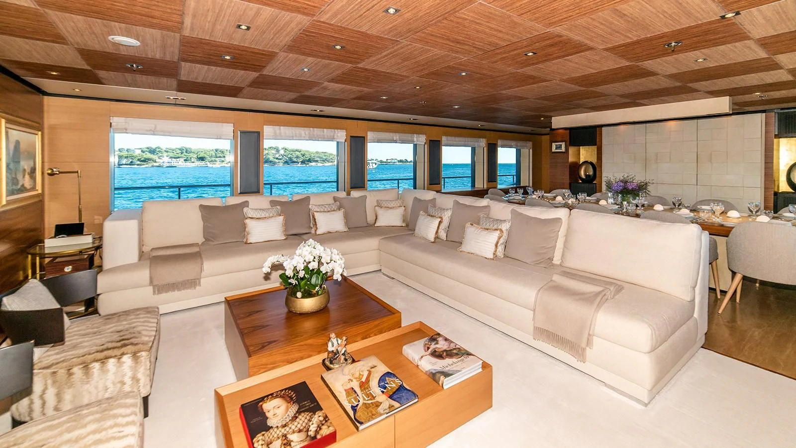 a living room with a large sofa and a large window aboard ALI BABA Yacht for Sale