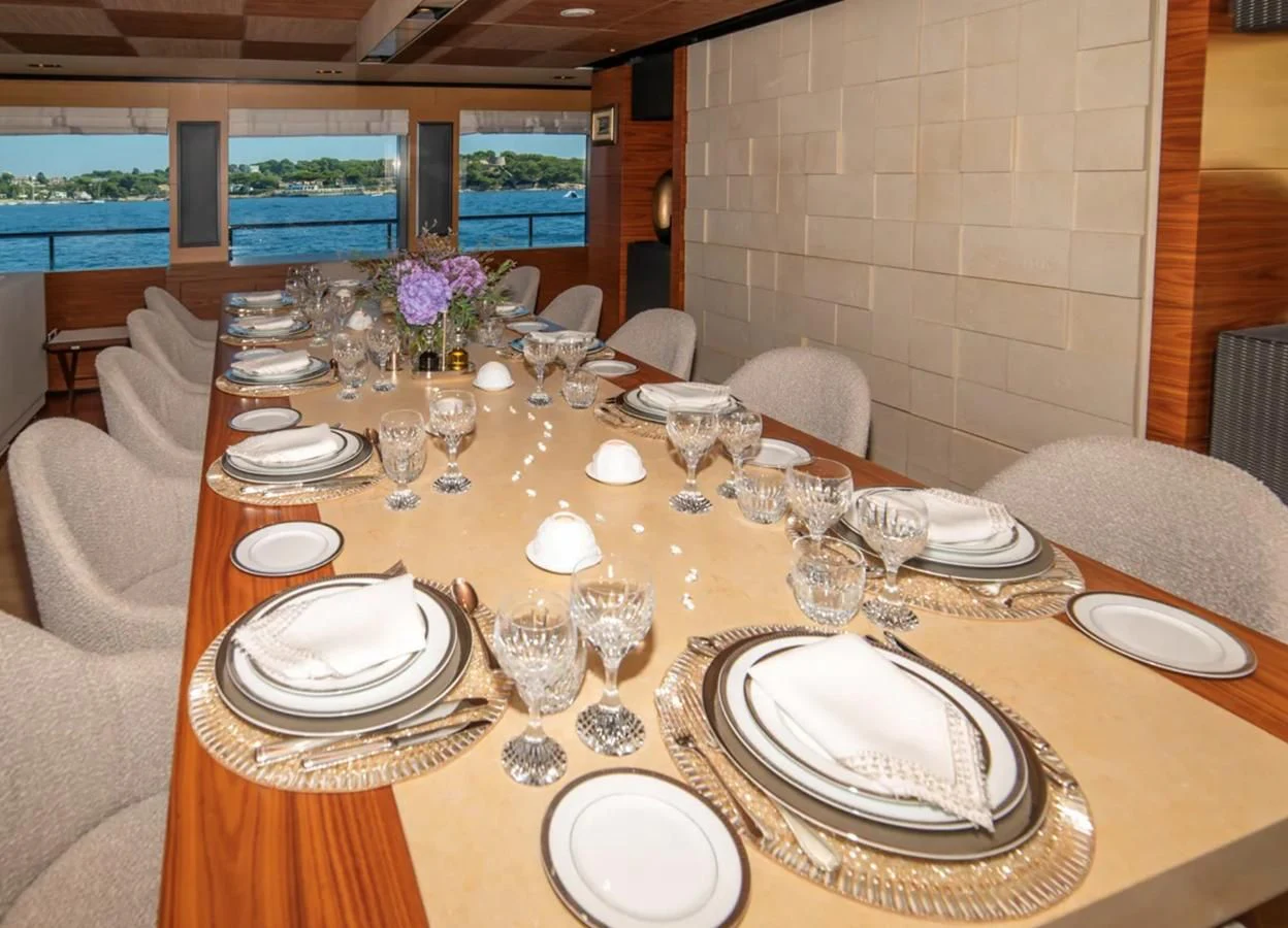 a table set with plates and glasses aboard ALI BABA Yacht for Sale