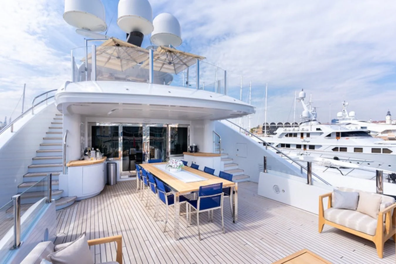 a large white building with a table and chairs on a deck aboard ALI BABA Yacht for Sale