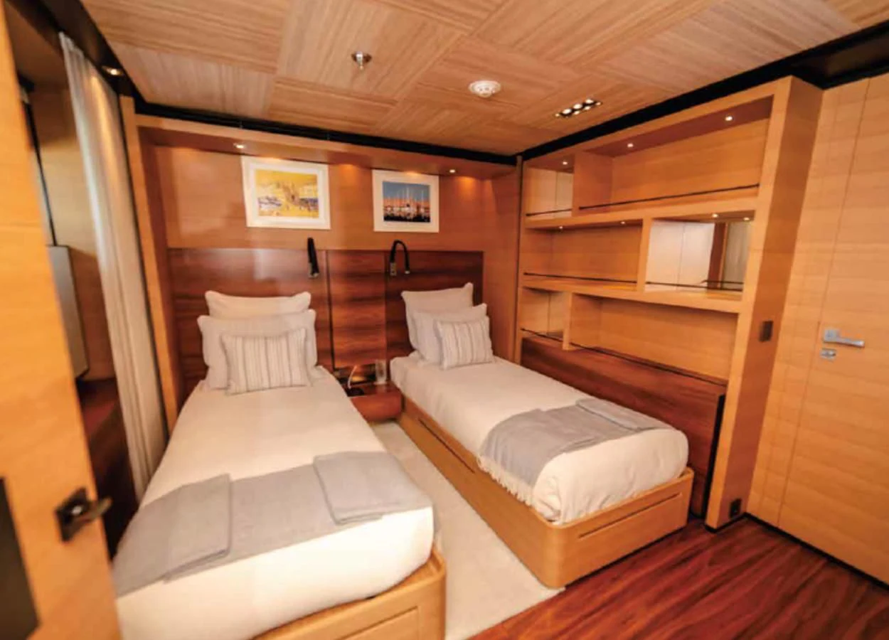 a room with a bed and a wood cabinet aboard ALI BABA Yacht for Sale