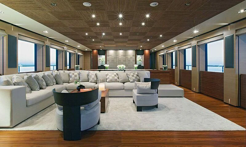 a living room with a large sectional sofa and a large window aboard ALI BABA Yacht for Sale
