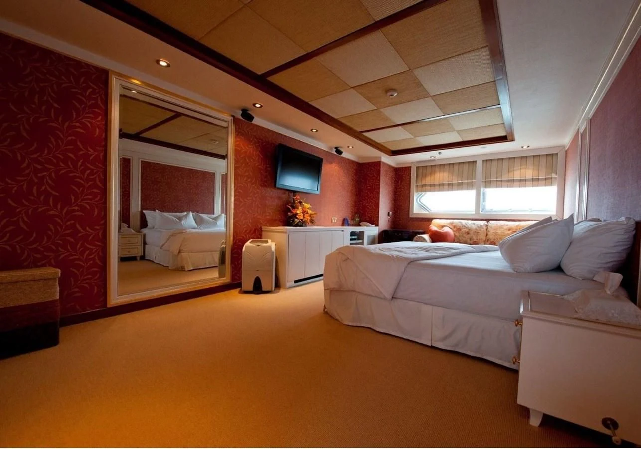 a bedroom with a bed and a tv aboard LANGKAWI LADY Yacht for Sale