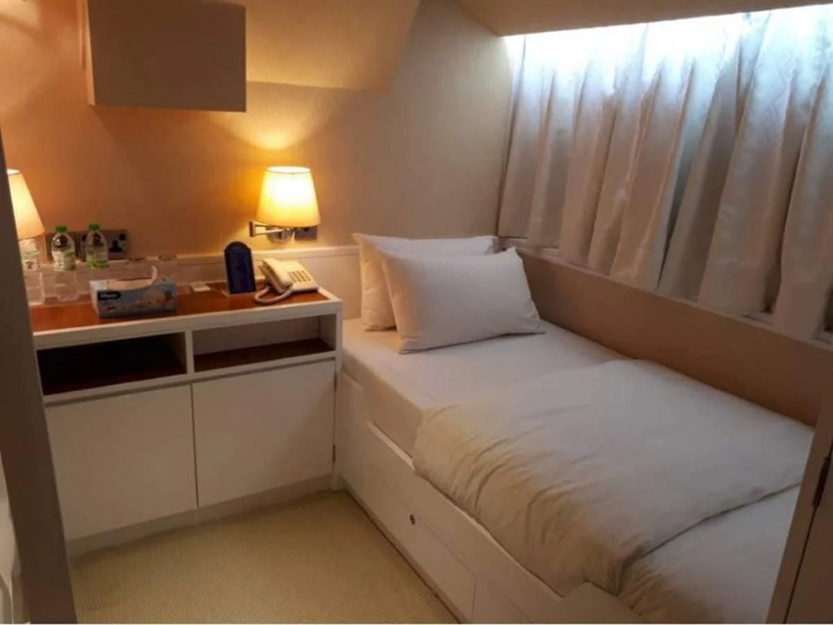 a bed with a white pillow and a white dresser aboard LANGKAWI LADY Yacht for Sale