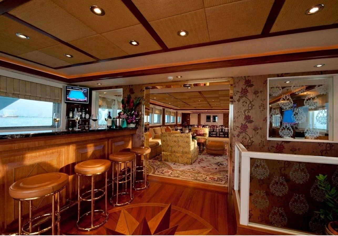 a room with a table chairs and a tv aboard LANGKAWI LADY Yacht for Sale