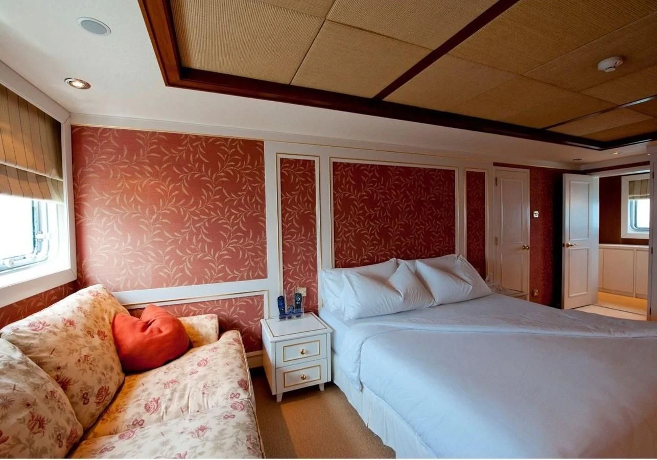 a bedroom with a bed and a couch aboard LANGKAWI LADY Yacht for Sale