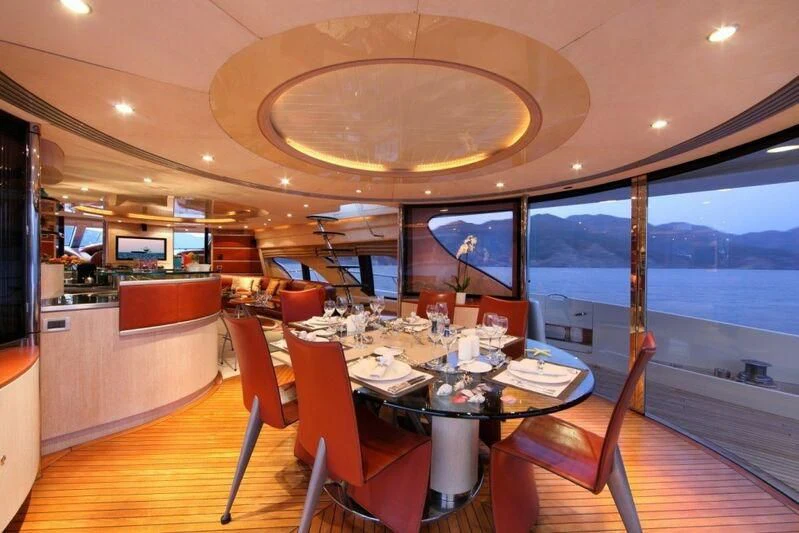a dining room with a large window aboard SKAZKA Yacht for Sale