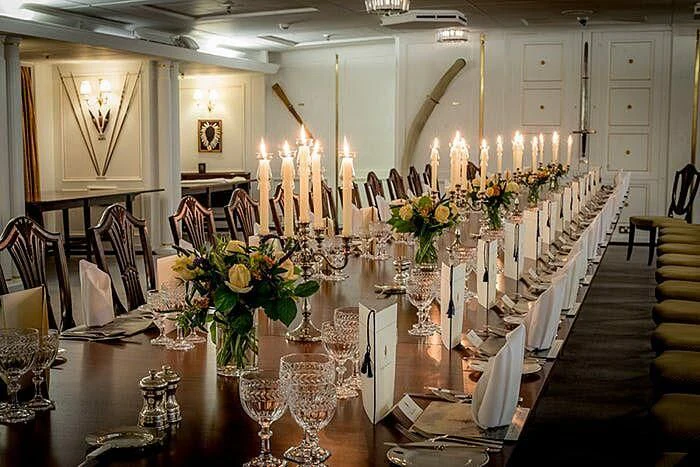 a long table with candles and flowers aboard BRITANNIA Yacht for Sale
