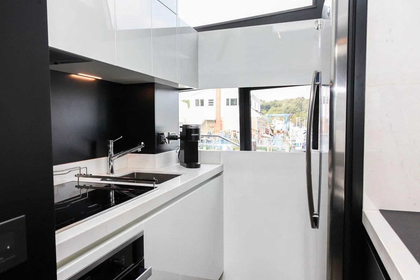 a kitchen with a sink and refrigerator aboard SUNSATION Yacht for Sale