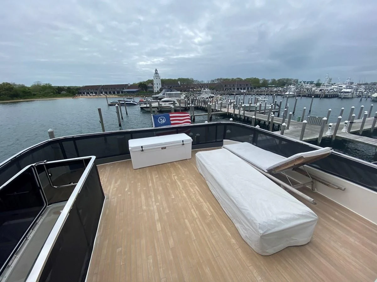 a deck with a flag on it and a body of water in the background aboard SUNSATION Yacht for Sale