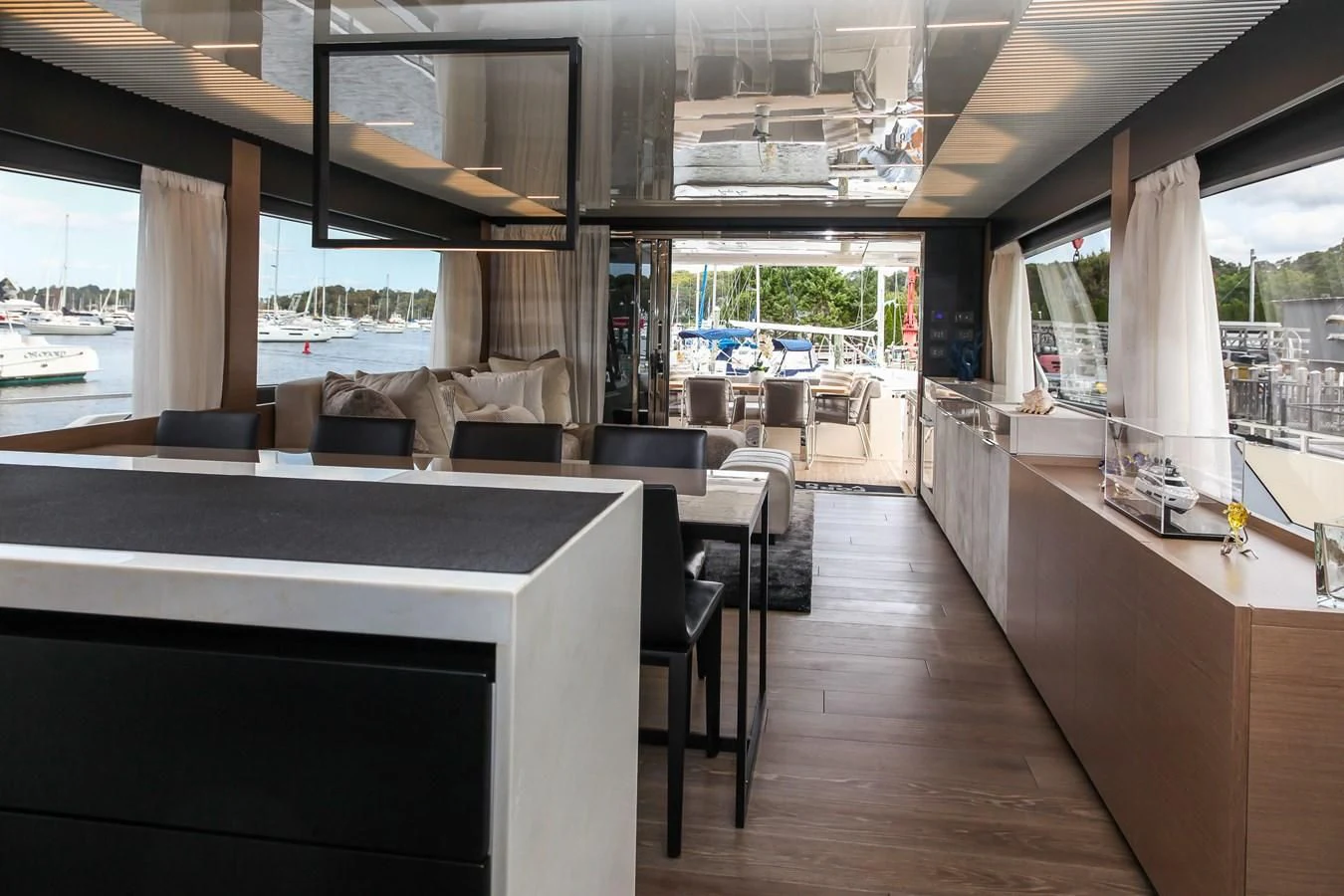 a room with a wood floor and a large window with a view of the water and the city aboard SUNSATION Yacht for Sale