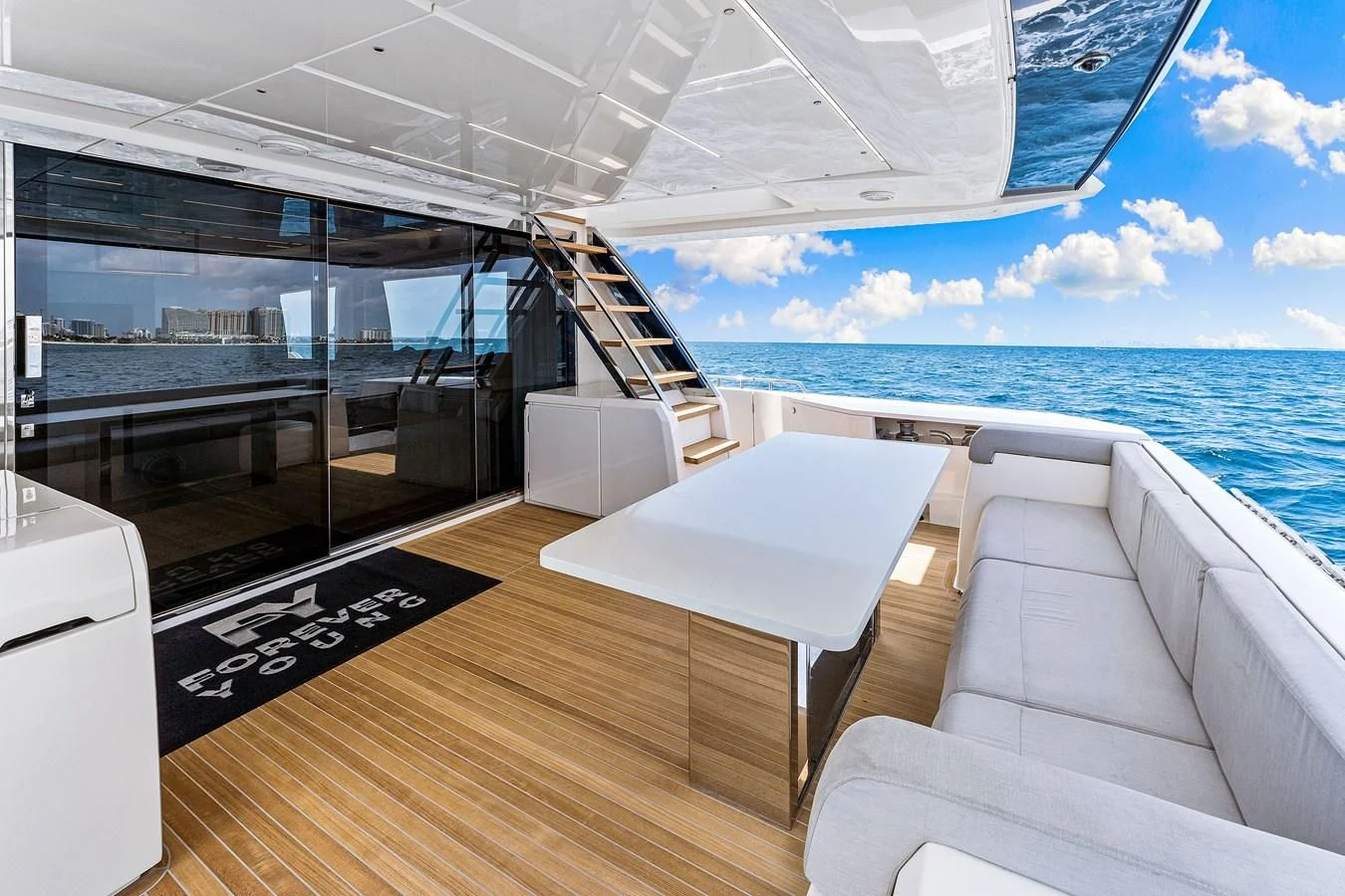 a room with a table and chairs on a deck overlooking the ocean aboard SUNSATION Yacht for Sale