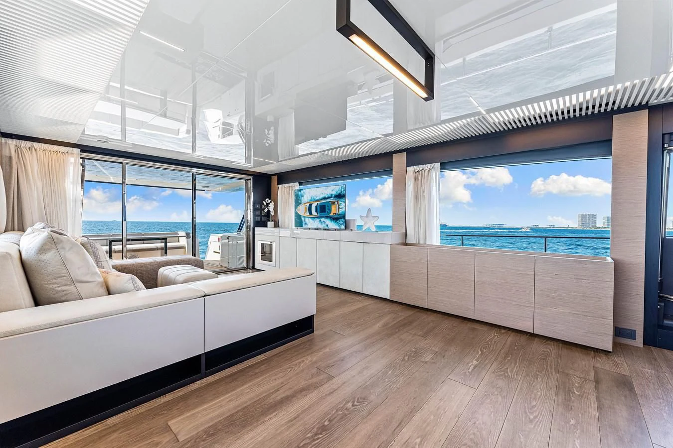 a room with a couch and a large window aboard SUNSATION Yacht for Sale