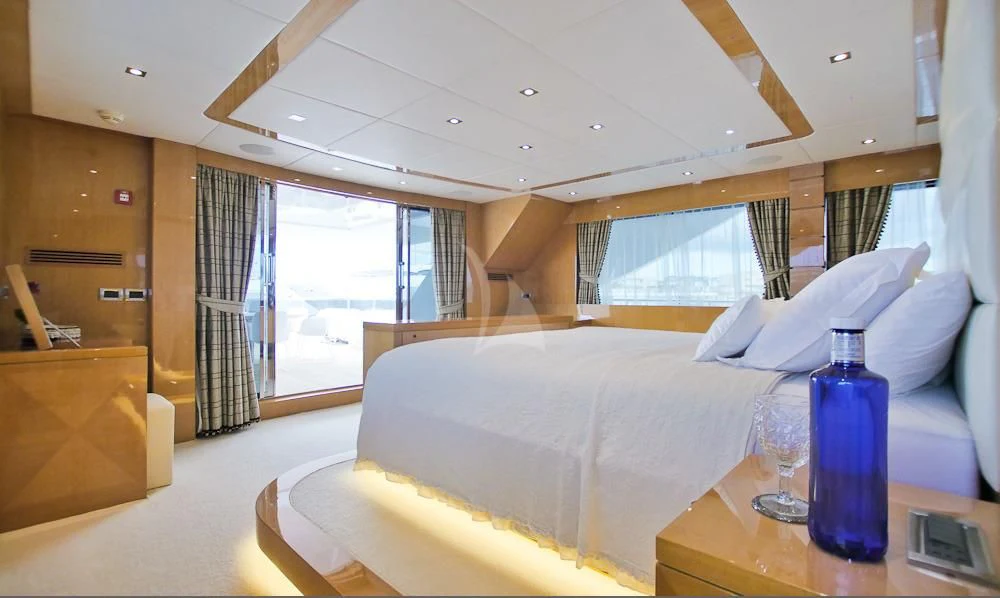 a bed with a bottle of water on it aboard VILLA SUL MARE Yacht for Sale