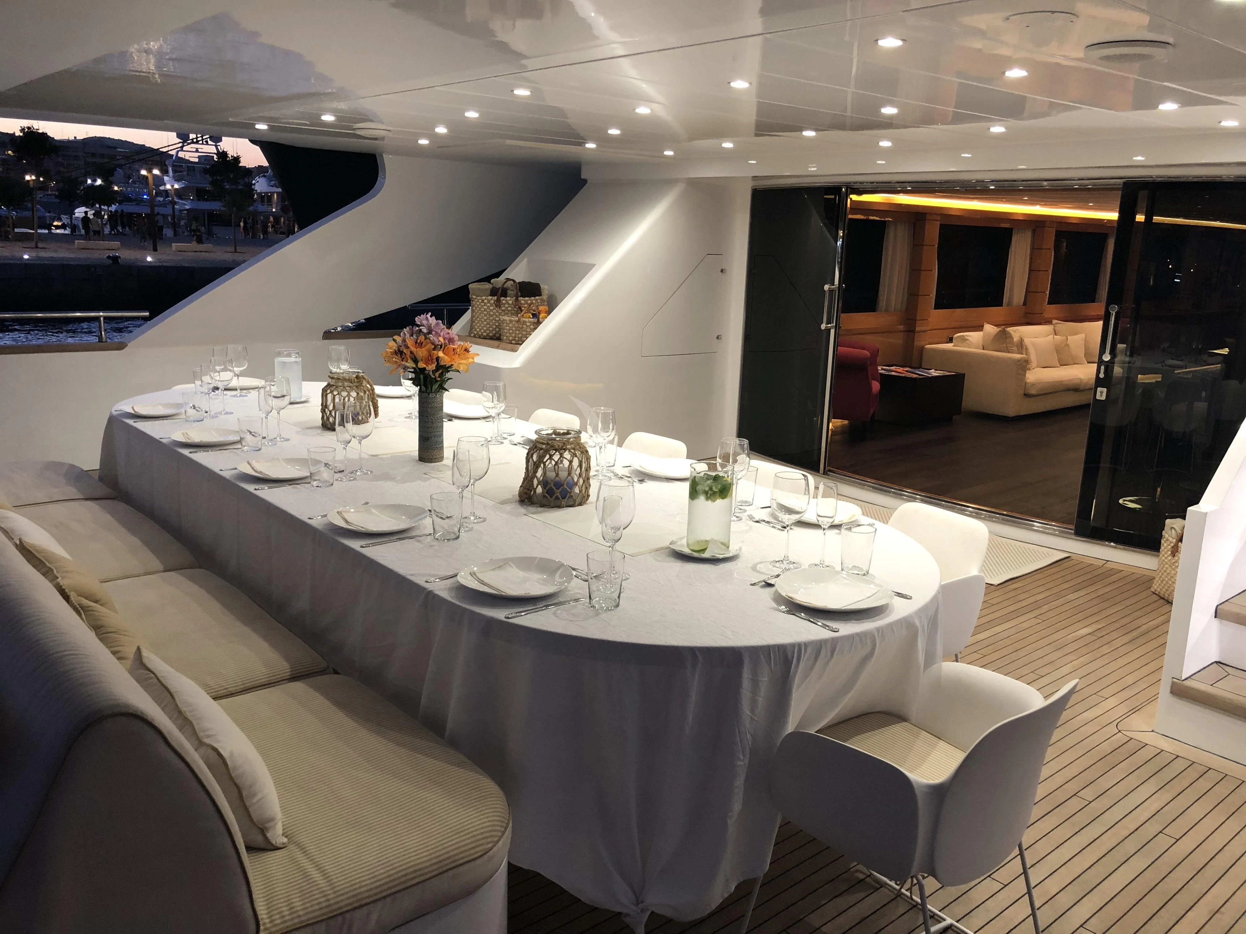 a table with wine glasses on it aboard VILLA SUL MARE Yacht for Sale