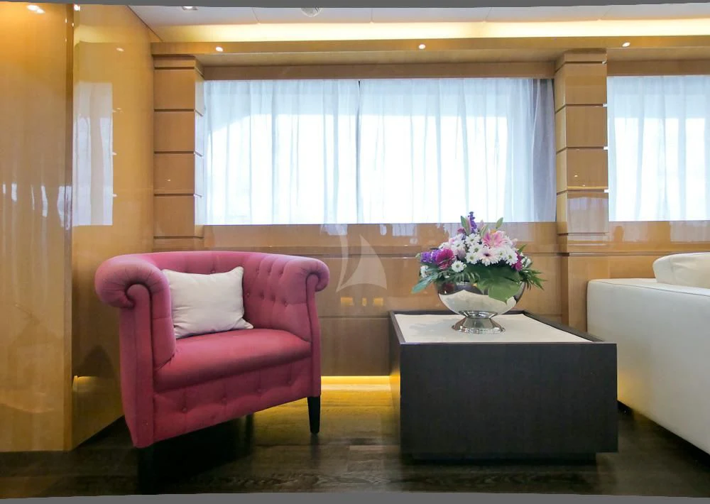 a pink chair next to a table aboard VILLA SUL MARE Yacht for Sale