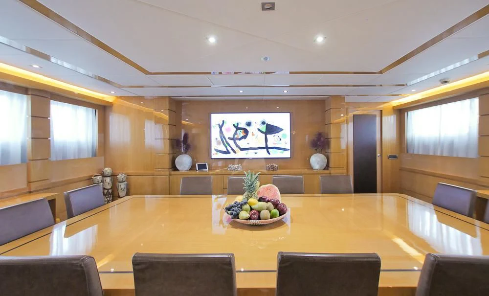 a large room with a table and chairs and a tv aboard VILLA SUL MARE Yacht for Sale