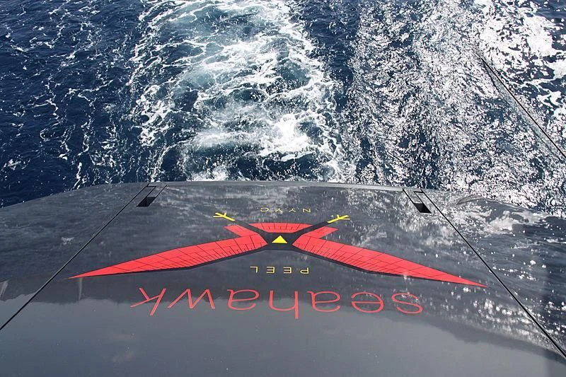 a red plane flying over a mountain aboard SEAHAWK Yacht for Sale